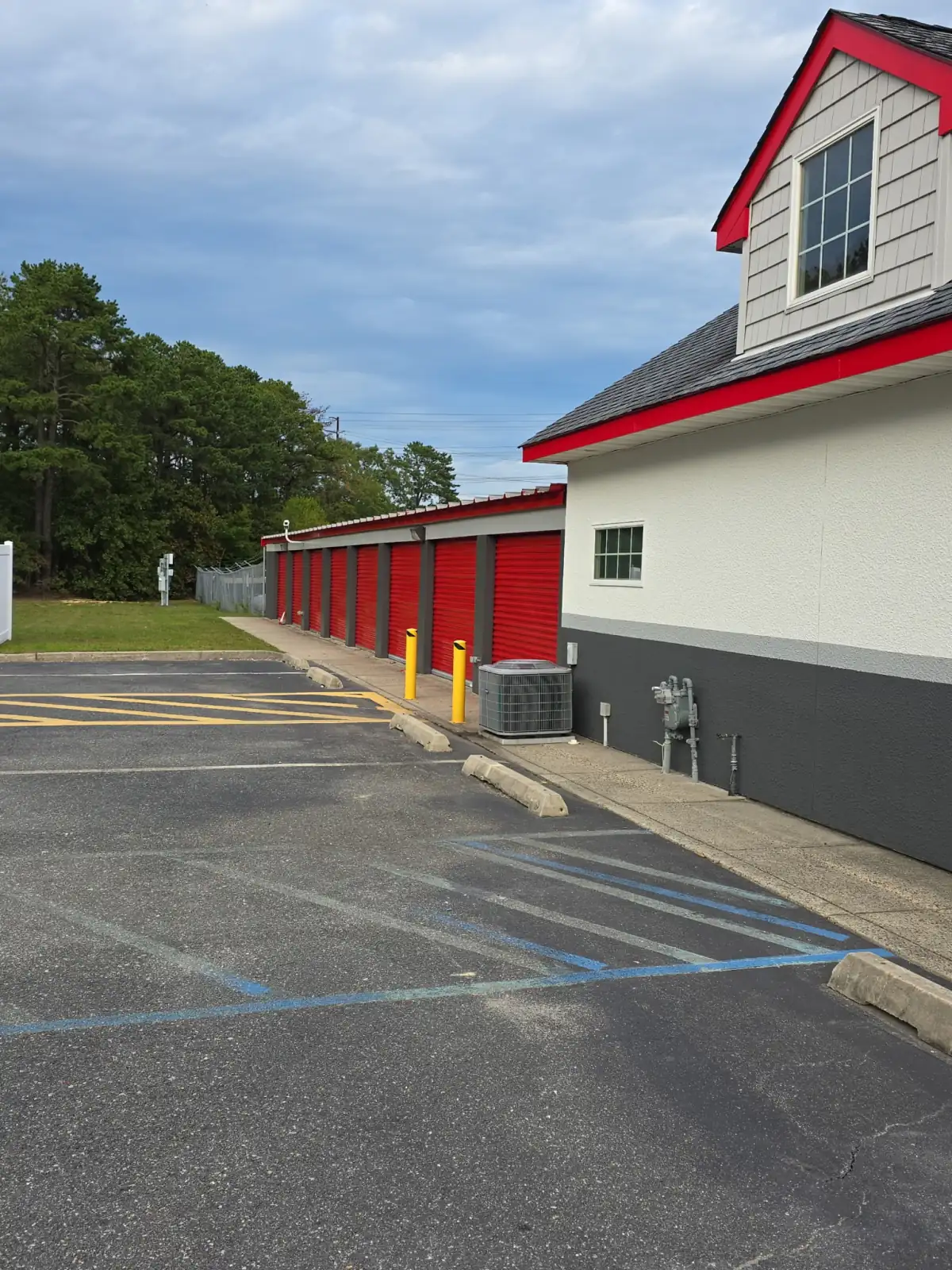 Self-storage facility with red roll-up doors and freshly painted trim by LVS Custom Paints